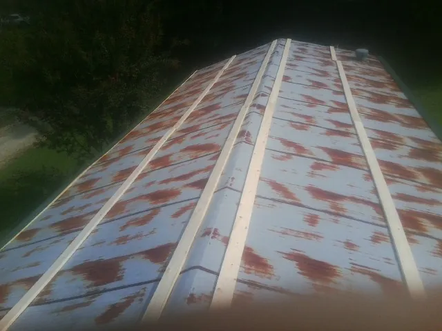 Rusted metal roof panels with new wood purlins before replacement — Storm Damage Roof Repair in Nemacolin by Roofing Brothers