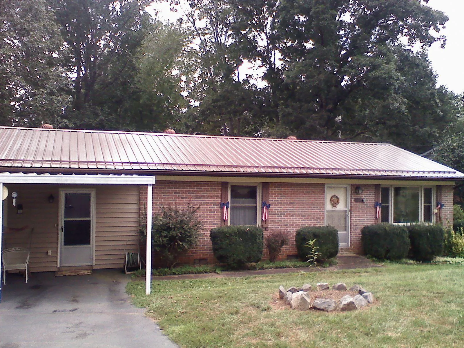Bronze metal roof and carport on a brick ranch home — Roof Repair work by our crew in Nemacolin